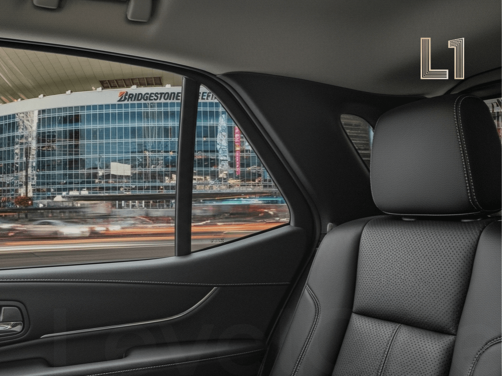 View from inside a calm luxury vehicle, looking out at a motion-blurred Bridgestone Arena at night, representing a solution to Nashville's logistical challenges.